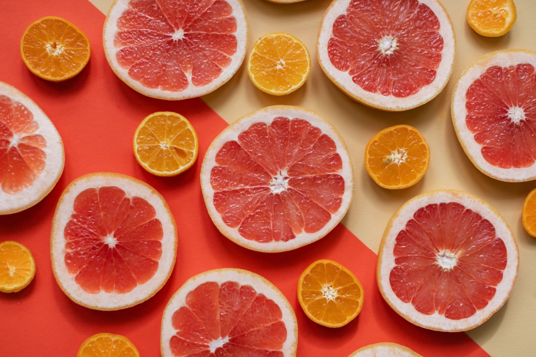 Bright and juicy slices of grapefruit and orange arranged on a bold, colorful background, highlighting freshness and nutrition.