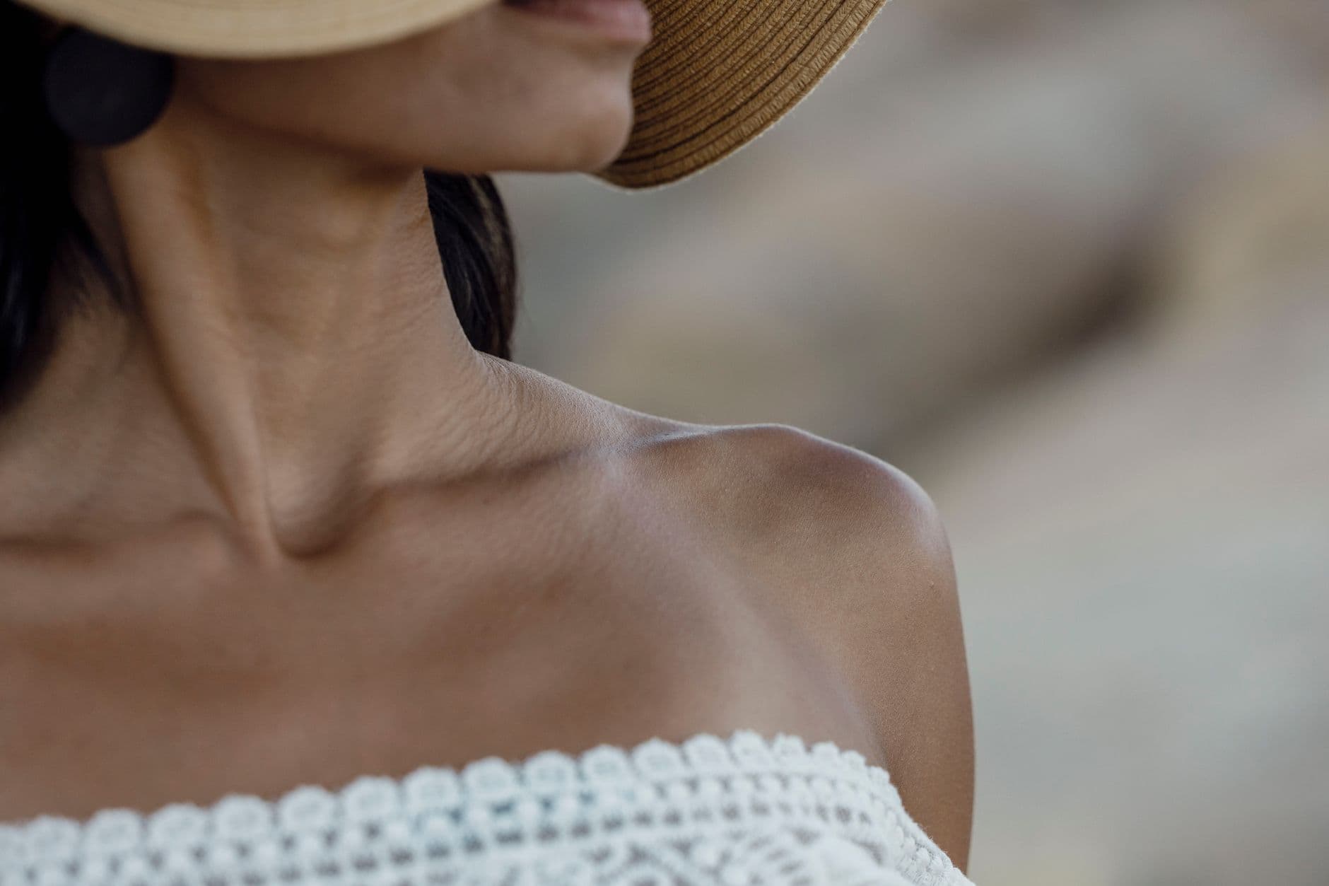 A person's neck, collarbone and shoulder in soft daylight