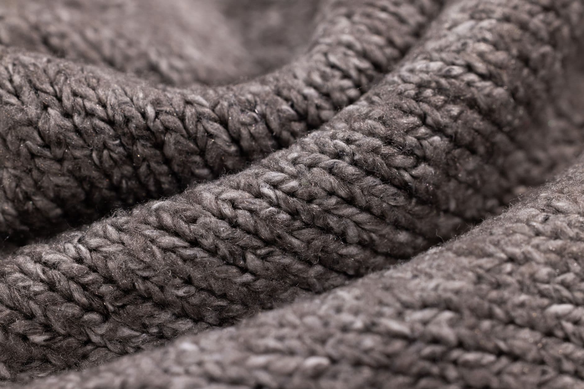 Close up of grey wool knit, folded to show the texture